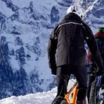 Dos bicicletas frente a una motanaña nevada y terreno nevado.