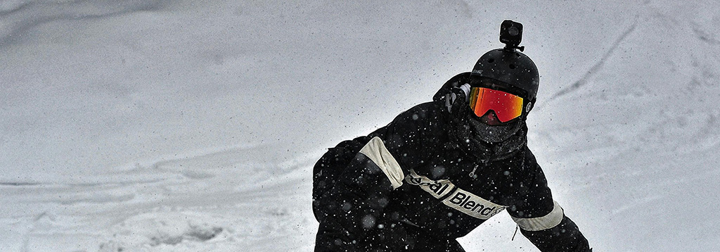 Persona haciendo snowboard con un fondo totalmente nevado