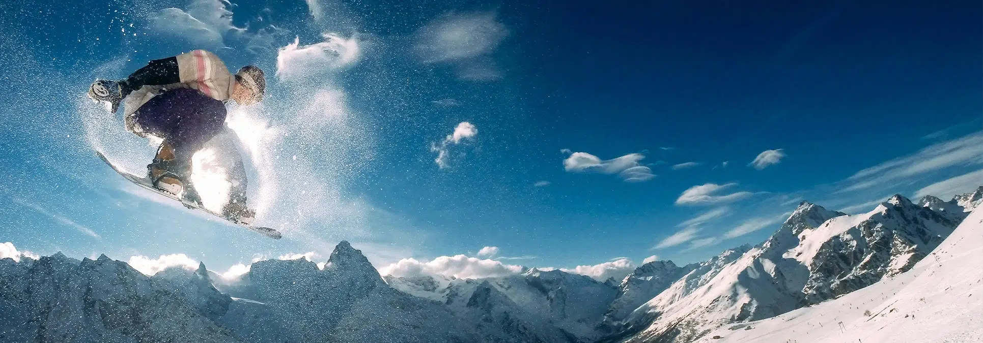 persona haciendop un truco de snow fentre un paisaje nevado