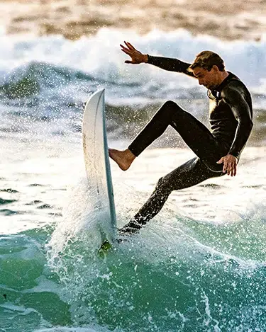 persona haciendo un truco de surf en una ola