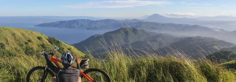 Imagenque muestra un paisaje verde junto con una bicicleta de montaña