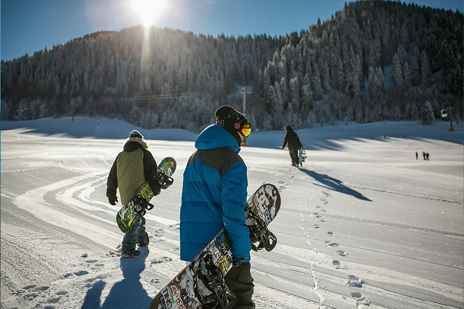 grupo de personas caminando por la nieve sujetando material de snow