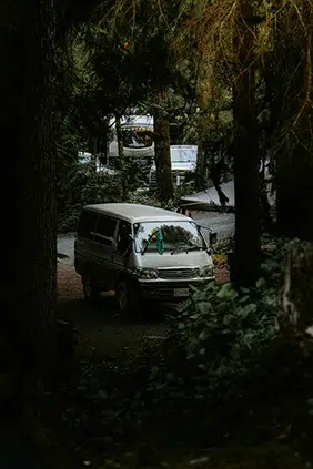 Imagen de una furgoneta en medio de un paisaje de arboles