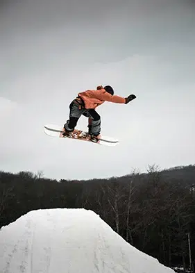 persona haciendo un truco de snowboard