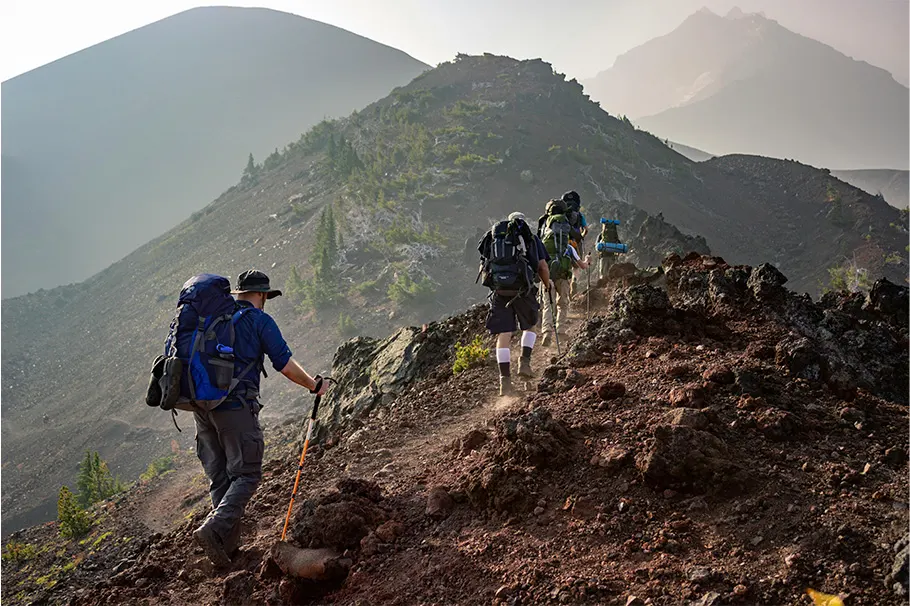 personas haciendo trekking en una montaña rocosa