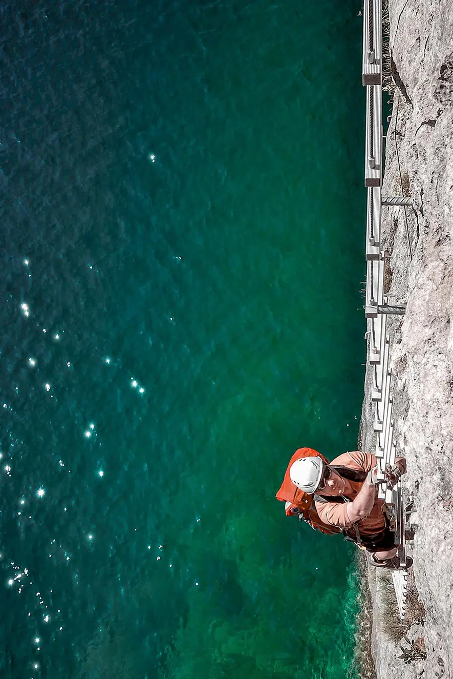 persona haciendo via ferrata sobre el mar