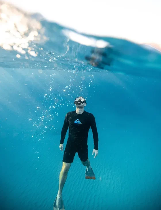 persona haciendo snorkel debajo del agua