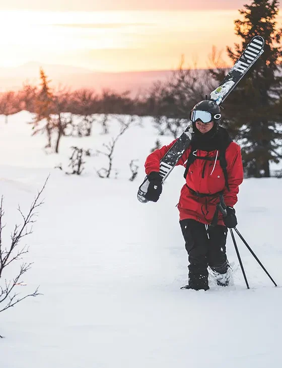 persona caminando por la nieve mientras lleva unos esquís